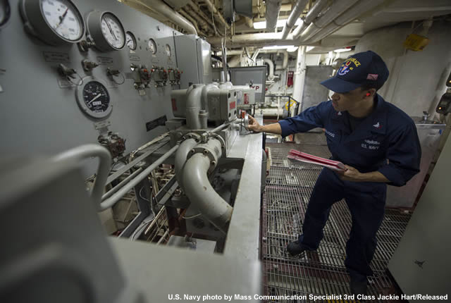 Navy personnel checking the temperature of the water intakes in the machinery room