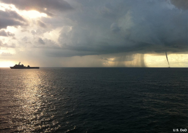 Photograph of a waterspout over the ocean with a ship off to the side
