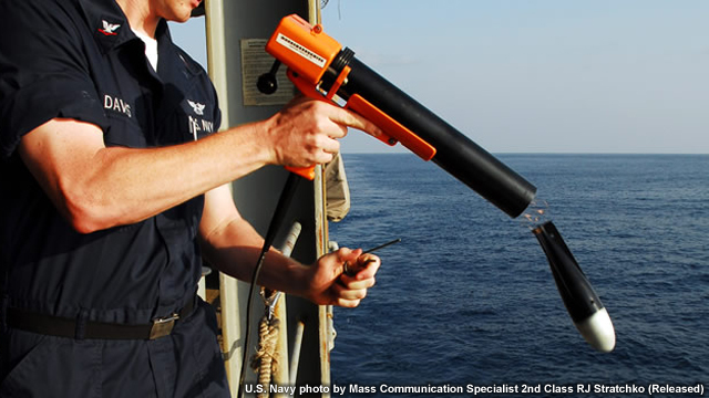 Aerographer's Mate 3rd Class Brandon Davis launches a Sippican MK-2 bathythermograph data acquisition system. The probe collects environmental data below the oceans surface with sensors measuring temperature and depth.