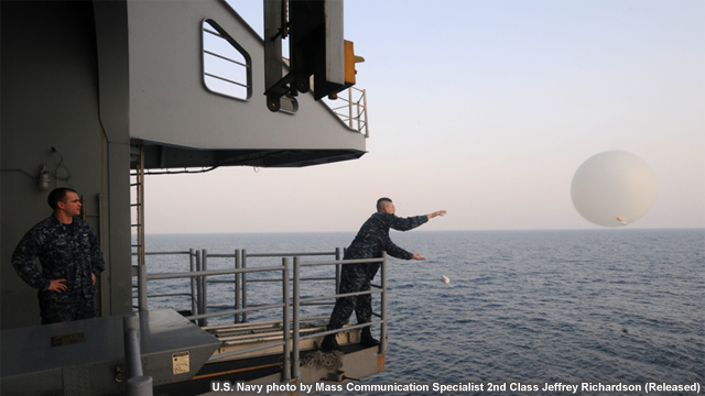 photo of aerographer launching a weather balloon from aboard a ship