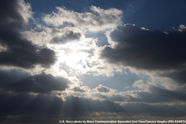 photo of sun through clouds over the ocean