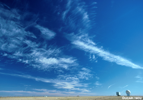 Thin white streaks of cirrostratus in a light blue sky.